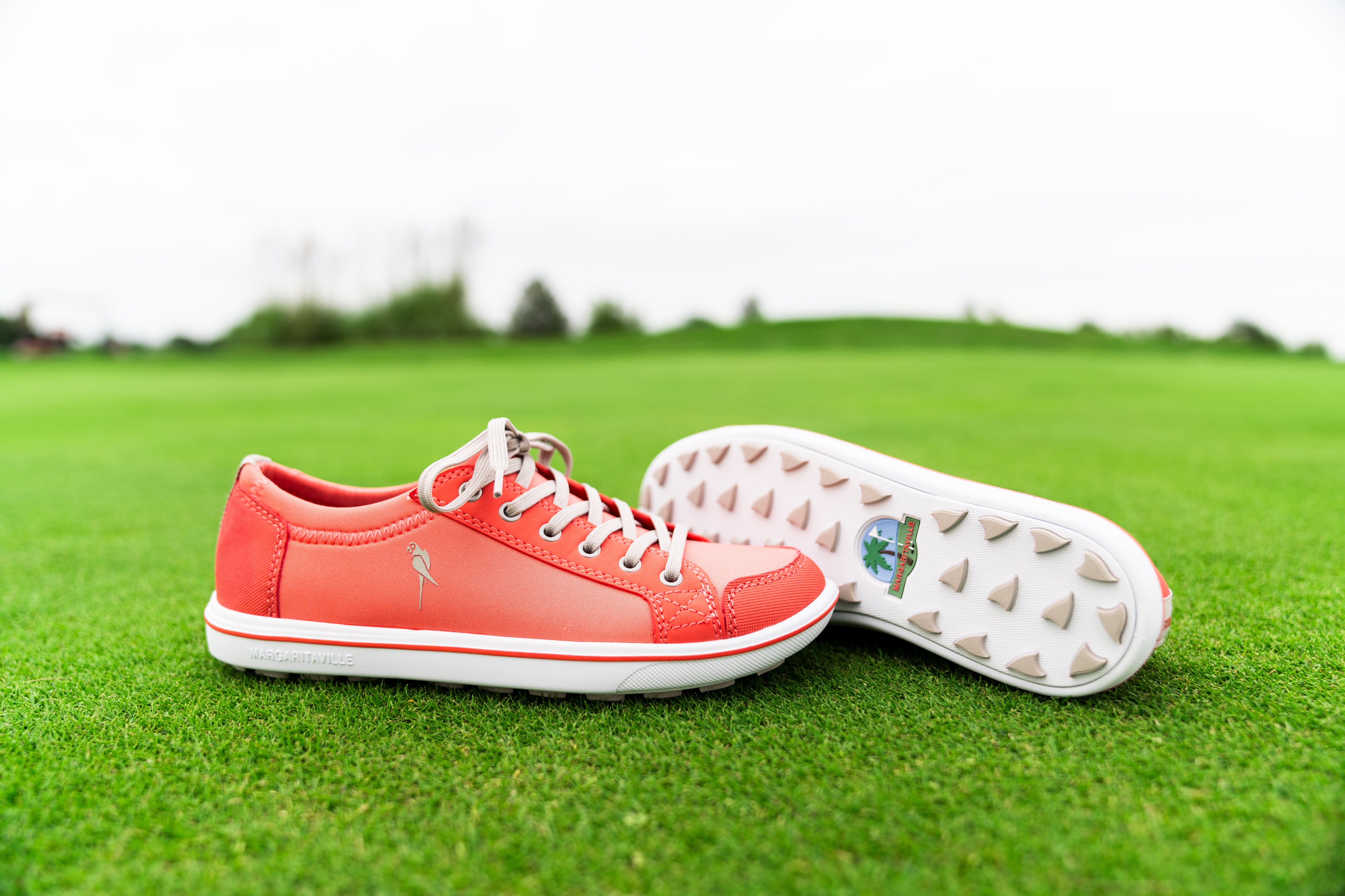 Coral-colored golf shoes with white soles